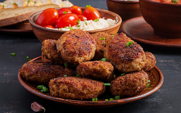 Juicy delicious meat cutlets on dark table. 