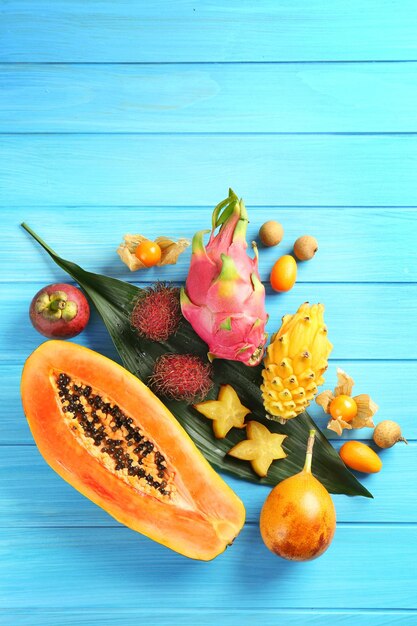 Photo juicy exotic fruits on blue wooden background