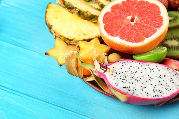 Photo juicy exotic fruits on blue wooden background