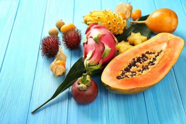 Juicy exotic fruits on blue wooden background