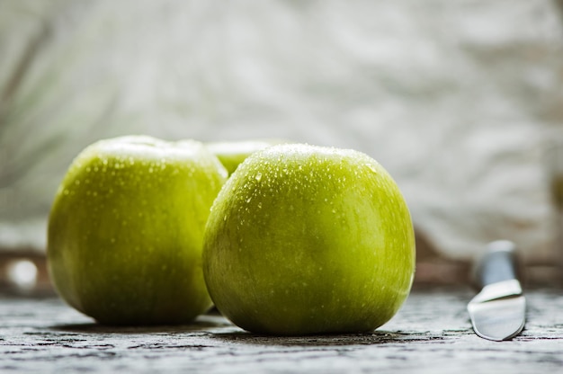 Juicy fresh yellow apples with water drops in a plateknife for cutting apples