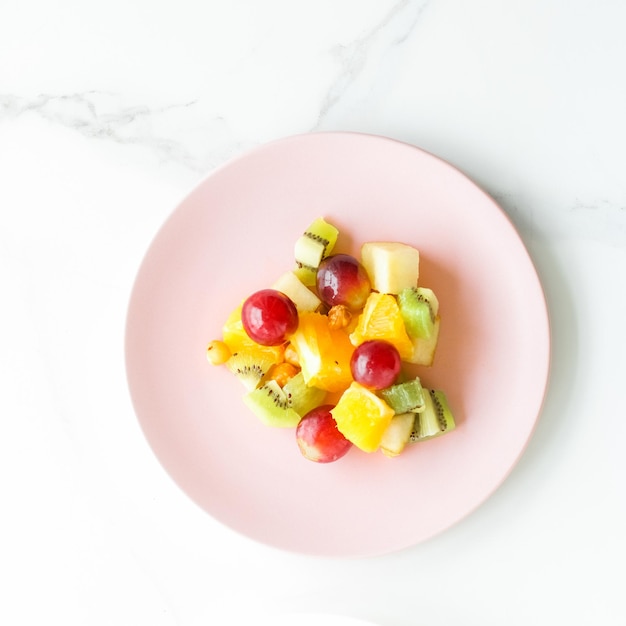 Сочный фруктовый салат на завтрак на мраморной плоской диете и концепции здорового образа жизни