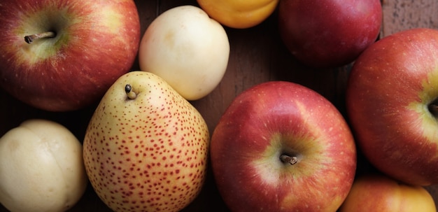 Juicy fruits on a old wooden table. Apples, pears, plums, apricots, close up.