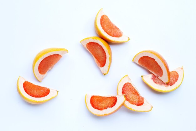 Juicy grapefruit slices on white surface