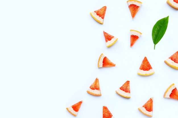 Juicy grapefruit slices on white surface