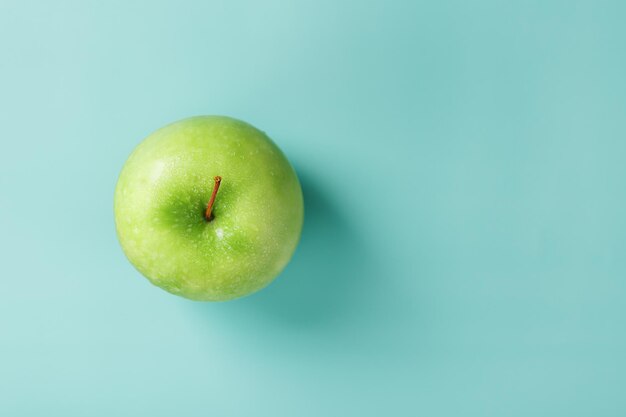 Juicy Green apple on a green background with a minimalistic composition. Top view, free space