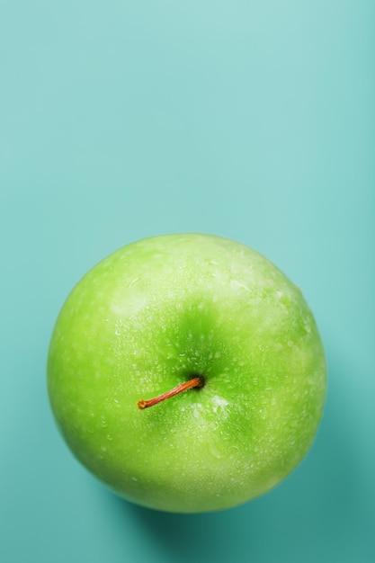 최소한의 구성으로 녹색 배경에 육즙 녹색 사과.