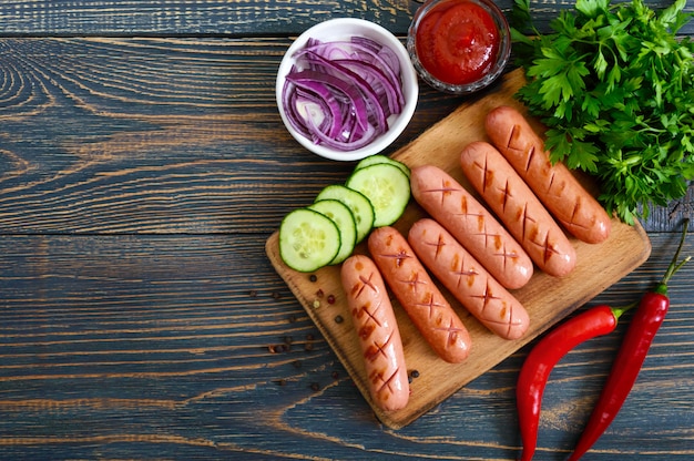 Juicy grilled sausages, sauce and fresh vegetables. Sausages for hot dog. Street food.