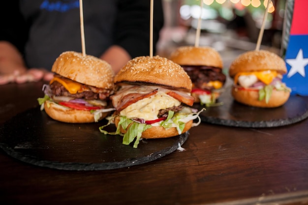 juicy hamburgers with cutlet with bacon on a wooden table street food