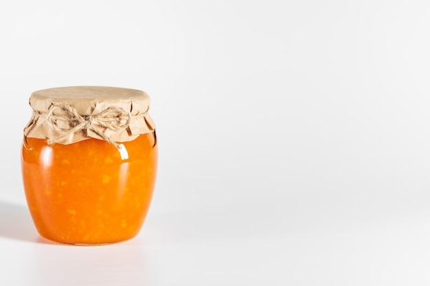 Juicy homemade jam in a glass jar on a white background