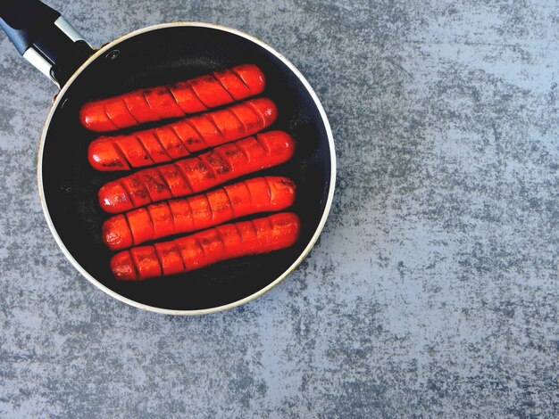 Juicy hot mini sausages in a small skillet.