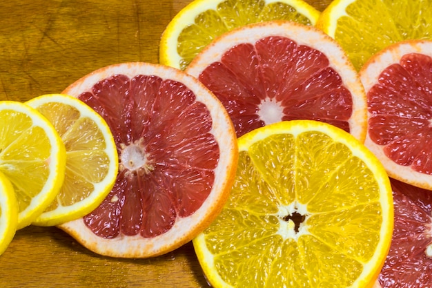 Juicy Orange and grapefruit rings on a wooden Board