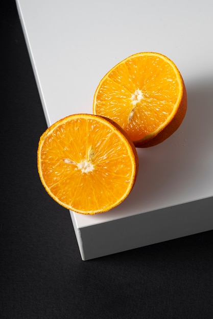 Juicy orange halves on a white square corner