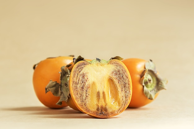 Juicy persimmon on a beige bed background. 



