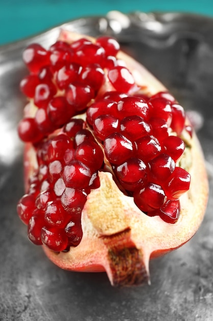Juicy pomegranate on metal tray closeup