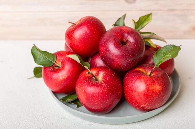 Juicy red apples in a bowl or plate on the table top view. Copy space.