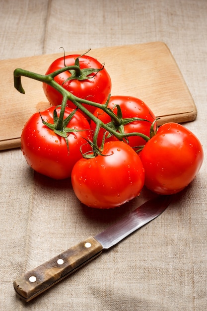 Сочные красные помидоры на разделочной доске и ноже
