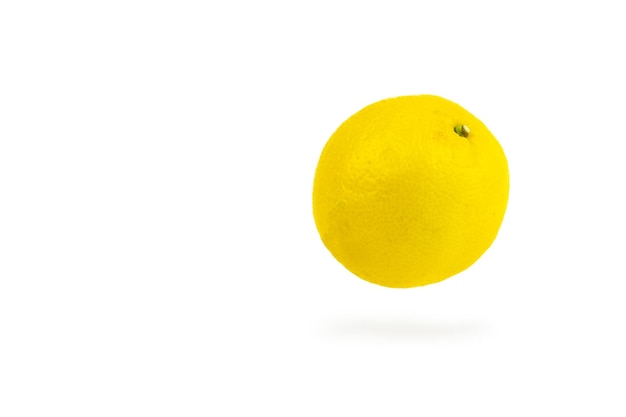 白い背景の上のジューシーな熟した空飛ぶ黄色いレモン..空中を飛んでいるレモンの抽象的なショット。