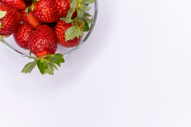 Juicy ripe red strawberries in a glass plate. A banner with red berries with a place for the text. The apartment was lying with a copy space. Summer vitamin dessert with strawberries. Delicious snack.