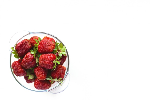 Juicy ripe strawberries in a bowl isolated on a white background with space for text