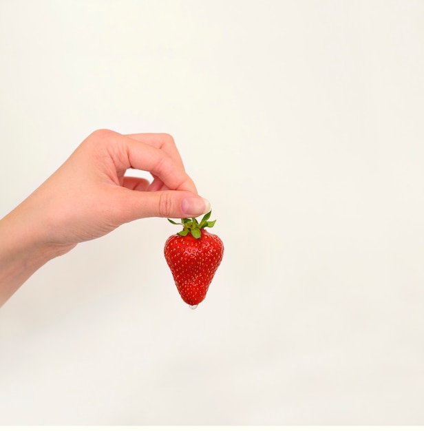 Juicy ripe strawberry in a woman's hand