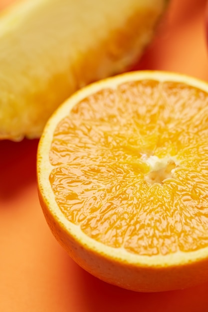 Juicy and ripe sweet vegetarian slice orange on yellow background close up