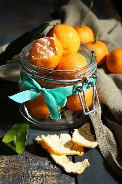 Juicy ripe tangerines with leaves on wooden table