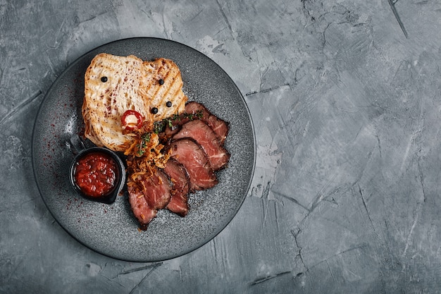 Juicy roast beef with ciabatta in tomato sauce is beautifully sliced and laid out on plates.