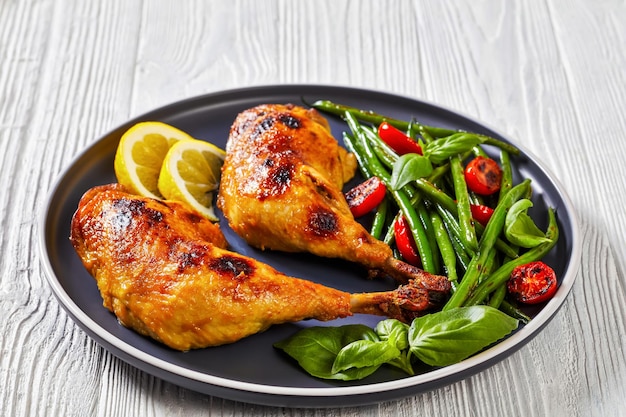 Photo juicy roast chicken legs with green beans salad