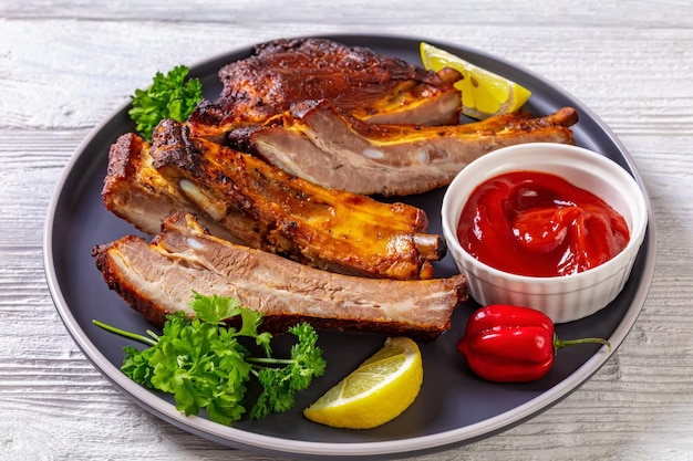 Juicy roast pork ribs on plate top view
