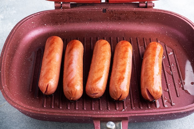 Photo juicy sausages roasted on the grill pan. close up.