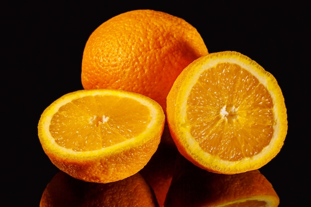 Photo juicy sliced orange on a black background