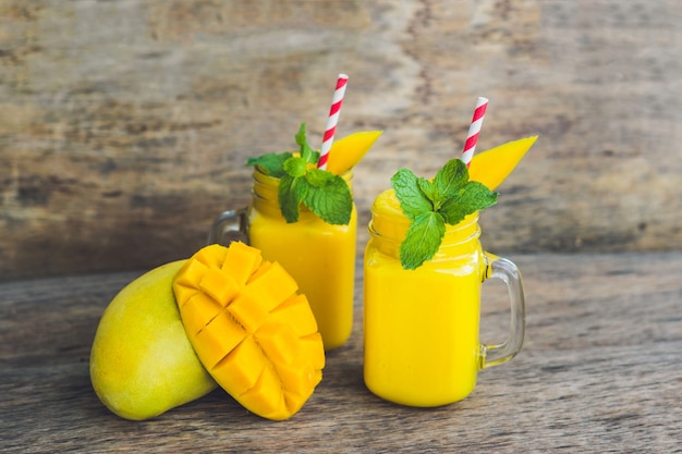 Juicy smoothie from mango in glasses with striped straw