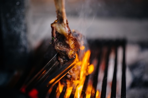 Juicy steak is grilled in a restaurant. Roasting meat in the fire on the grill.