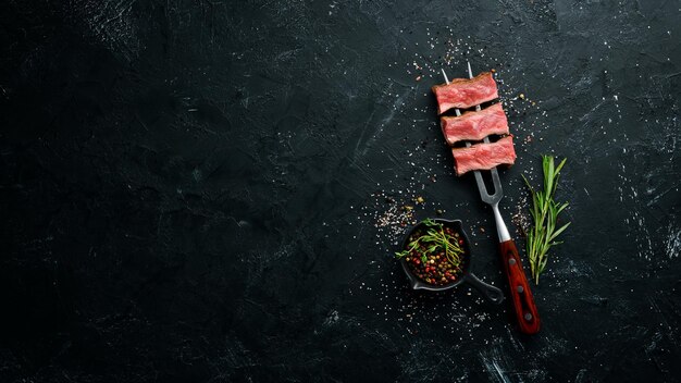 Juicy Steak op de vork met kruiden en specerijen Bovenaanzicht Vrije ruimte voor uw tekst