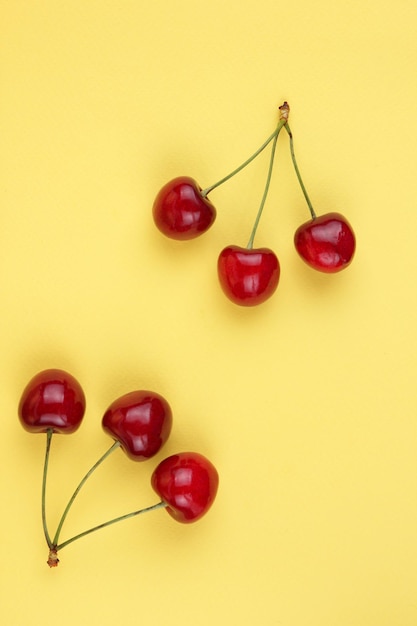 Juicy sweet red cherries on a yellow background Healthy food concept Closeup of sweet berries