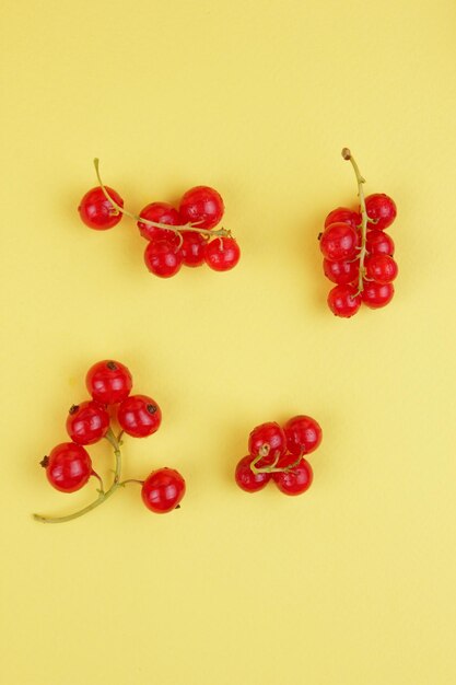 Juicy sweet red currant berries on a yellow background Healthy food concept Closeup of sweet berries