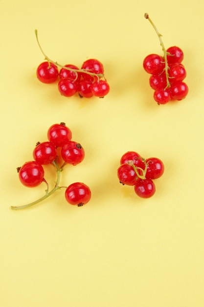 Juicy sweet red currant berries on a yellow background Healthy food concept Closeup of sweet berries