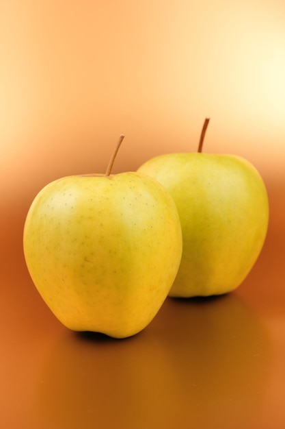 Juicy sweet two green apples on a golden background Healthy food concept Closeup of a green fruit