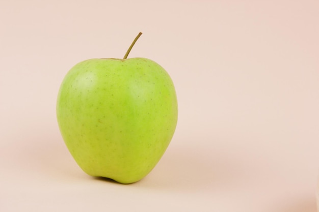 Juicy sweet whole apple on a pink background Healthy food concept Closeup of a sweet fruit