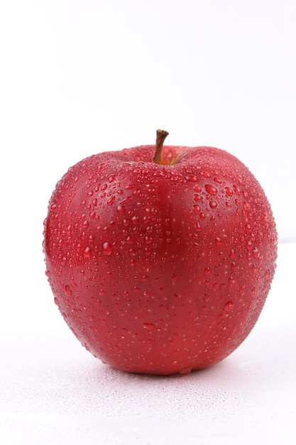 白い背景に分離されたジューシーな甘い全体の赤いリンゴ 健康食品のコンセプト 赤い果実のクローズ アップ