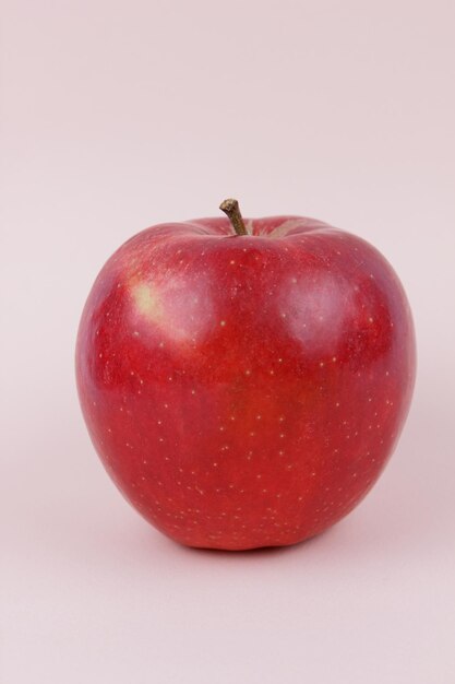 Juicy sweet whole red apple on a light background Healthy food concept Closeup of a red fruit