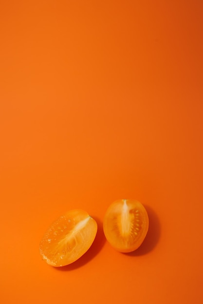 Juicy tasty yellow tomatoes on a bright orange background full screen