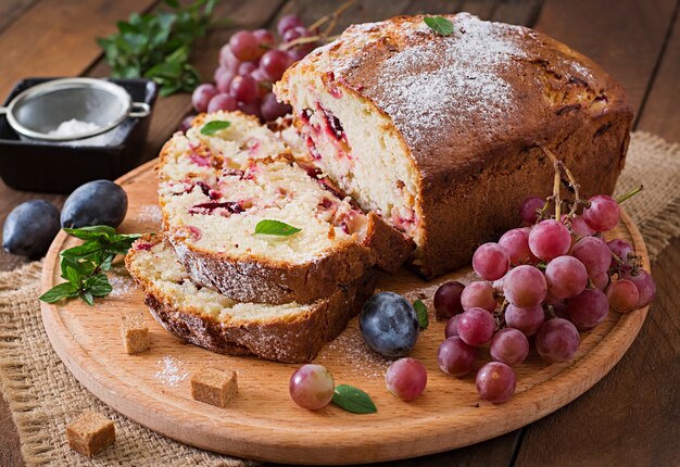 Juicy and tender cupcake with plums and grapes