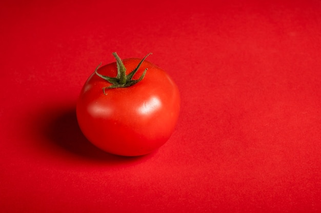 Juicy tomatoes on a bright red surface