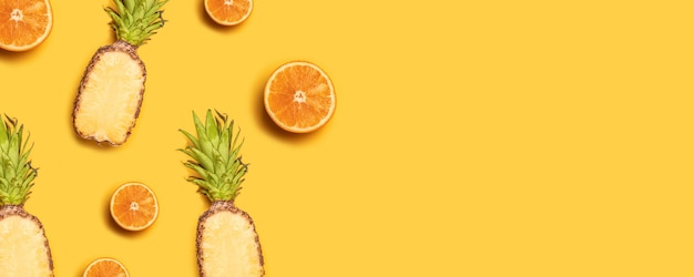 Photo juicy tropical fruits on a yellow background: oranges, coconuts, lemons, pineapples.