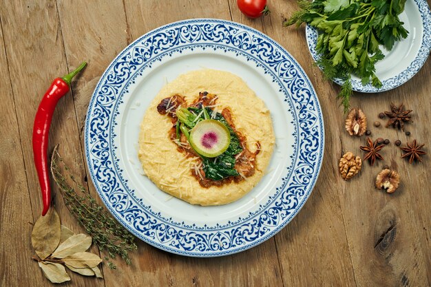polenta, 옥수수 죽 반찬과 육즙과 특이한 이스라엘 치킨 스테이크 (Pargiyot). 구운 치킨. 목재 표면