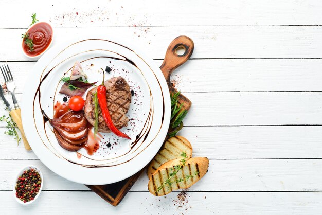 Juicy veal steak with chili pepper and pear on a plate Top view Free copy space