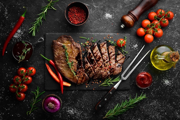 Juicy veal steak with spices thyme and rosemary Top view Flat lay top view on black stone cutting table