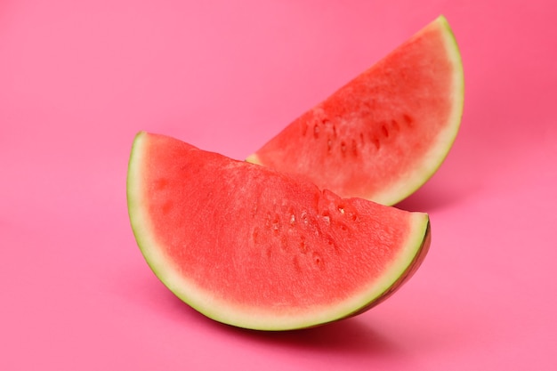 Photo juicy watermelon slices on pink background, close up